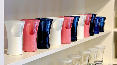 工房鈴蘭の直営店の白い棚に、ネイビー・ホワイト・ピンクの「ふたつの窓」のぐいのみが並んでいる写真